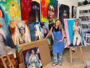 Steffi Goddard in her studio surrounded by her paintings of women